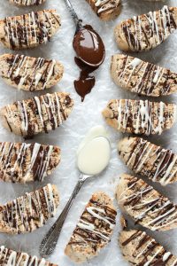 Tender and crumbly Amaretto Biscotti chock full of roasted almonds, chocolate covered almonds and drizzled with more chocolate.