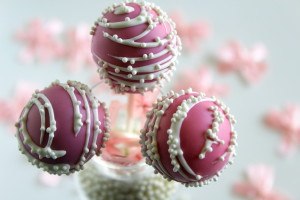 Pink coloured cake pops in a glass jar.