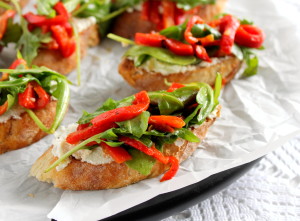 Crostini topped with arugula and roasted peppers.