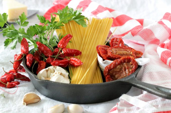 Sun dried tomatoes, garlic, parsley and spaghetti ingredients in a skillet.