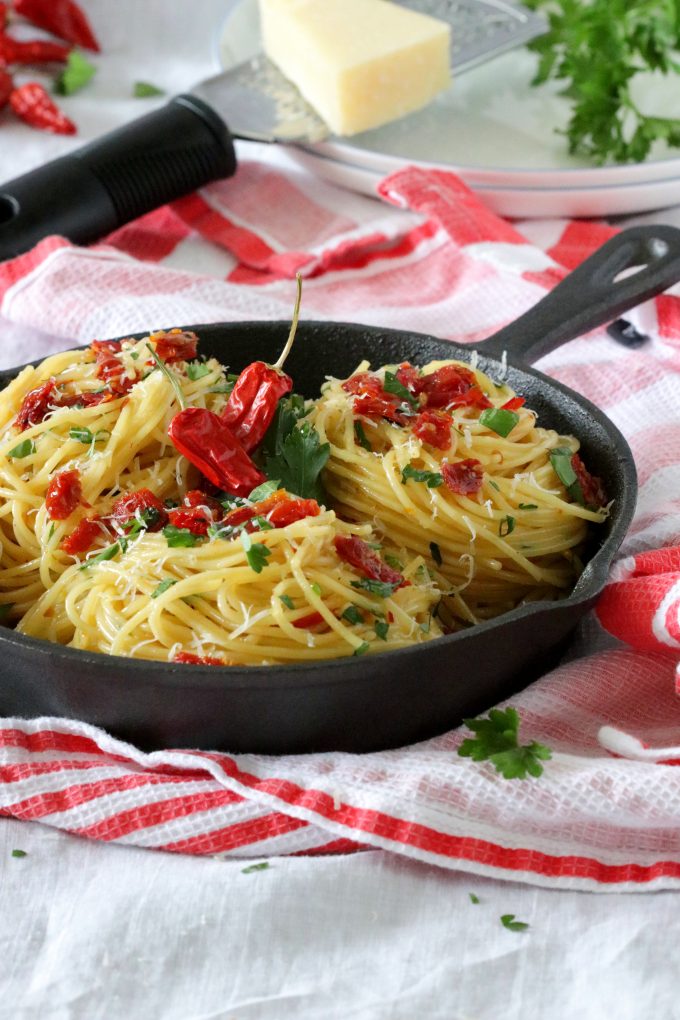 Sun dried tomatoes with spaghetti in a black skillet