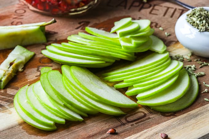 Sliced granny smith apples on a cutting board