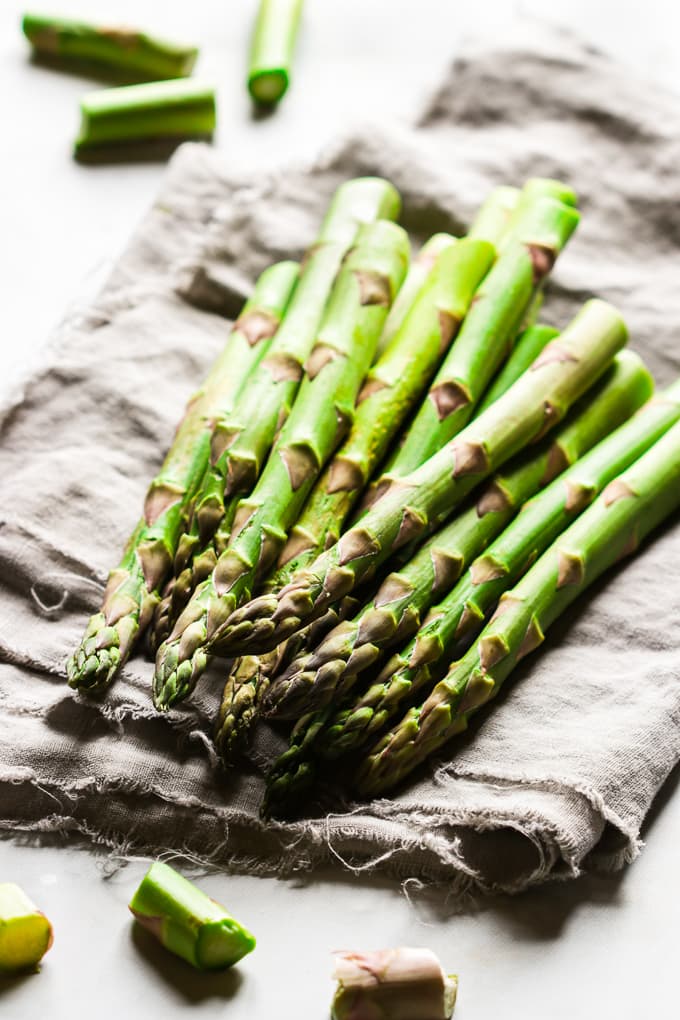 Bright green asparagus stalks on a cloth kitchen napkin.