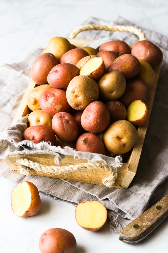 Red and golden baby creamer potatoes in a basket.