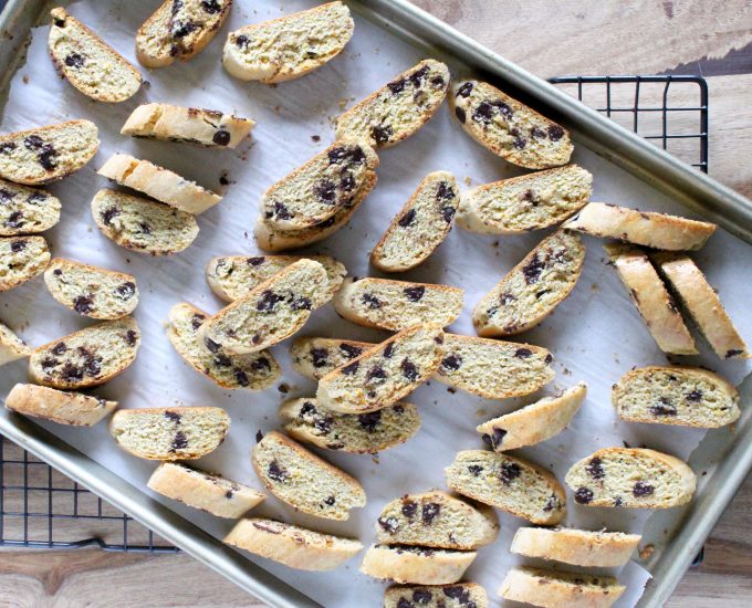 Sliced chocolate chip biscotti on a parchment lined baking tray.