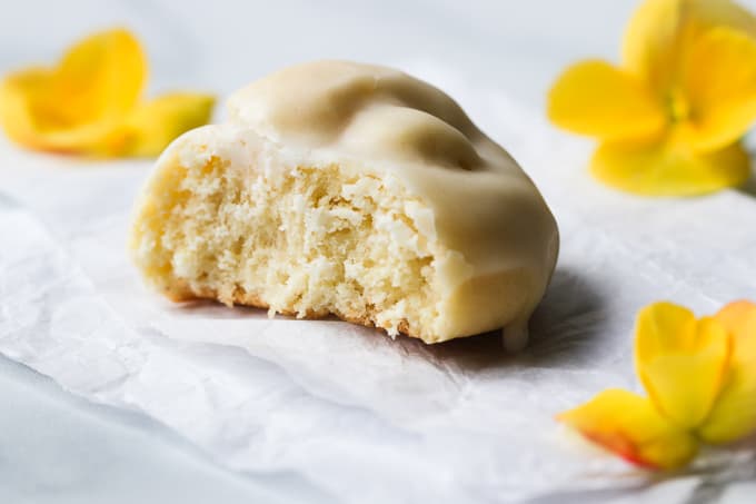 A half eaten tarallucci al limone cookie on a white napkin.