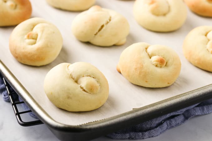 Freshly baked tarallucci cookies on a baking tray.