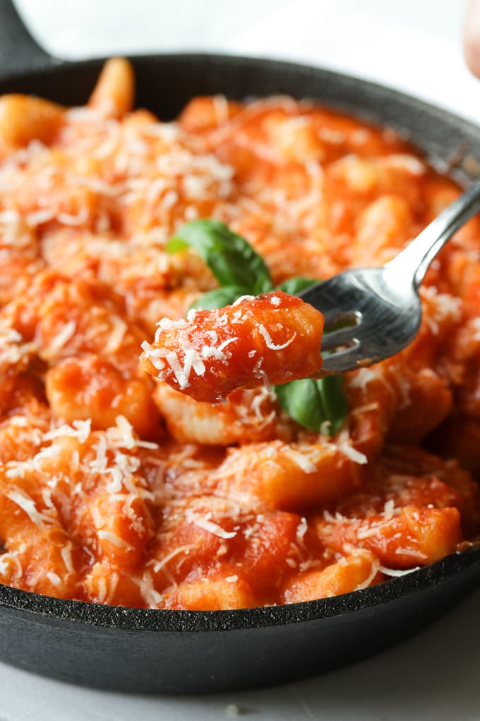 A forkful of gnocchi in tomato sauce.