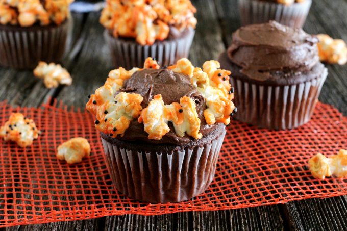 Decorating cupcakes with orange chocolate popcorn.