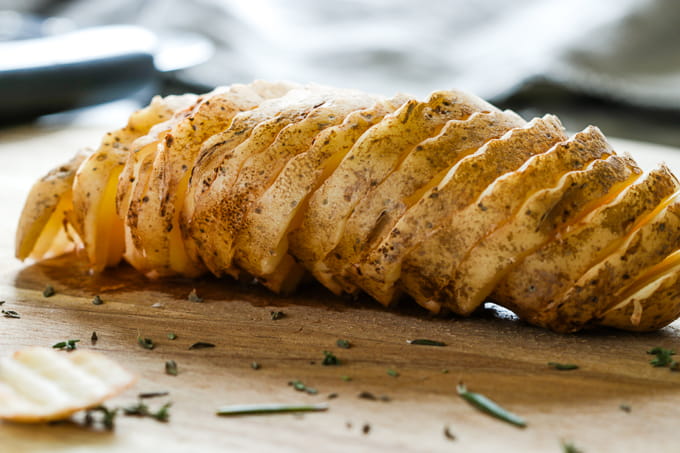 Sliced potato on a wooden cutting board.