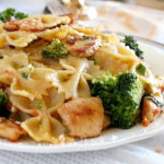 A serving of pasta with broccoli and chicken on a plate.