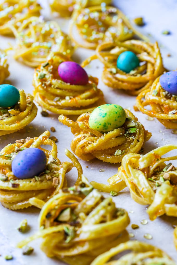 Deep fried linguine pasta nests, soaked in honey and topped with candy coated Easter chocolate eggs.