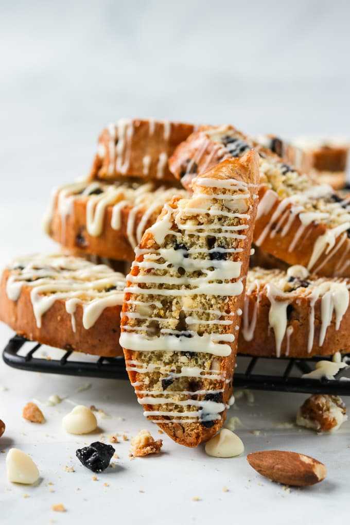 Lemon biscotti with wild blueberries on a cooling rack.