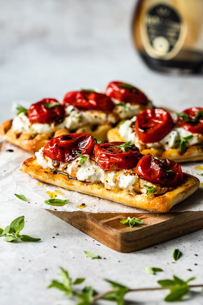 Three slices of pan grilled buns topped with whipped ricotta and roasted tomatoes.