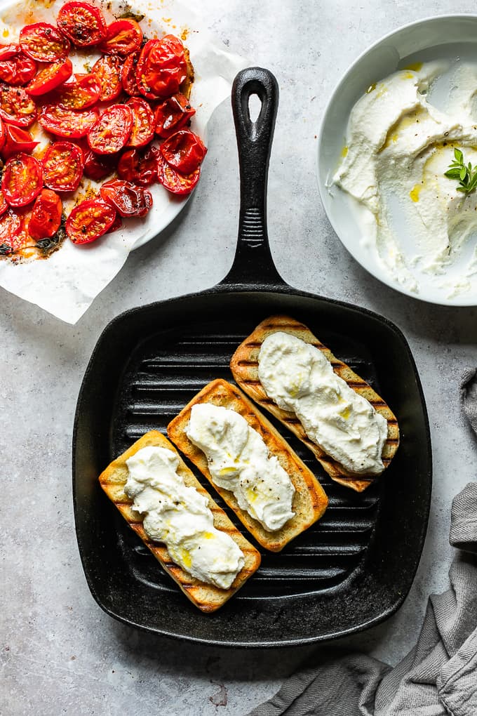 A grill skillet with three buns topped with whipped ricotta.