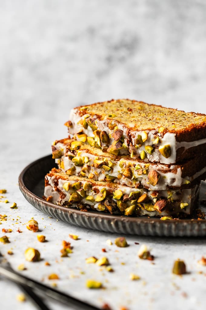 Three slices of almond pistachio cake on a plate.