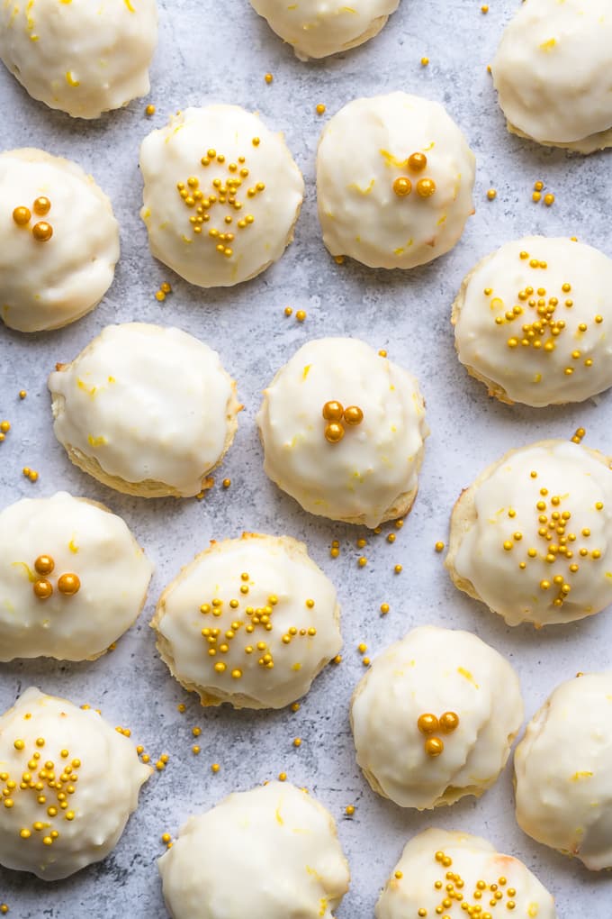 Lemon cookies with ricotta topped with a glaze and golden sprinkles.