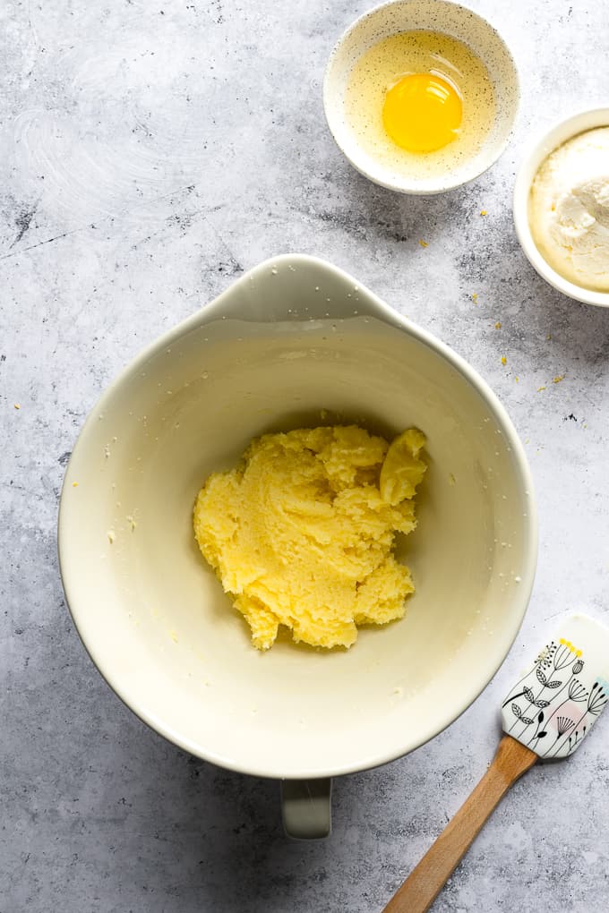 Beaten butter and sugar in a white mixing bowl.