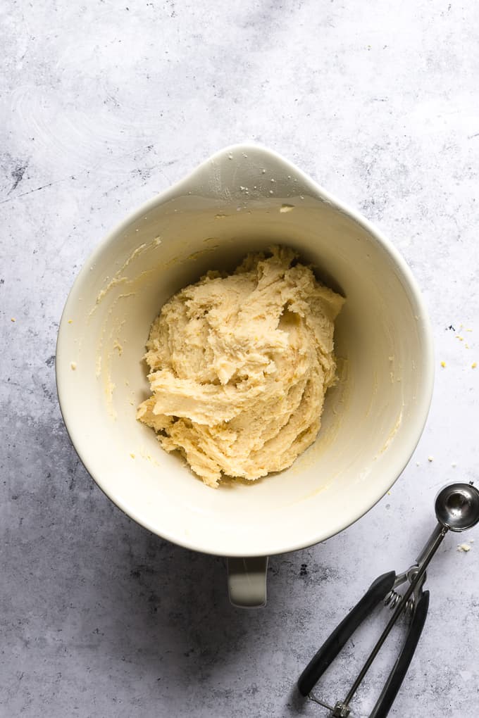 A white mixing bowl filled with lemon ricotta cookies batter.