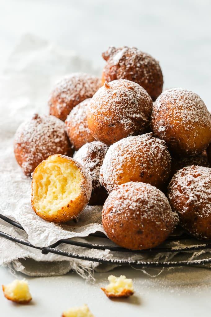 Ricotta zeppole piled on a rack.