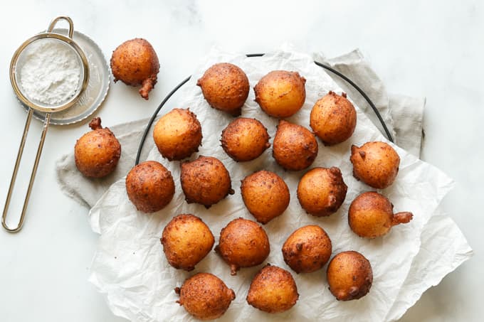 Depp fried zeppole batter on a paper lined platter.