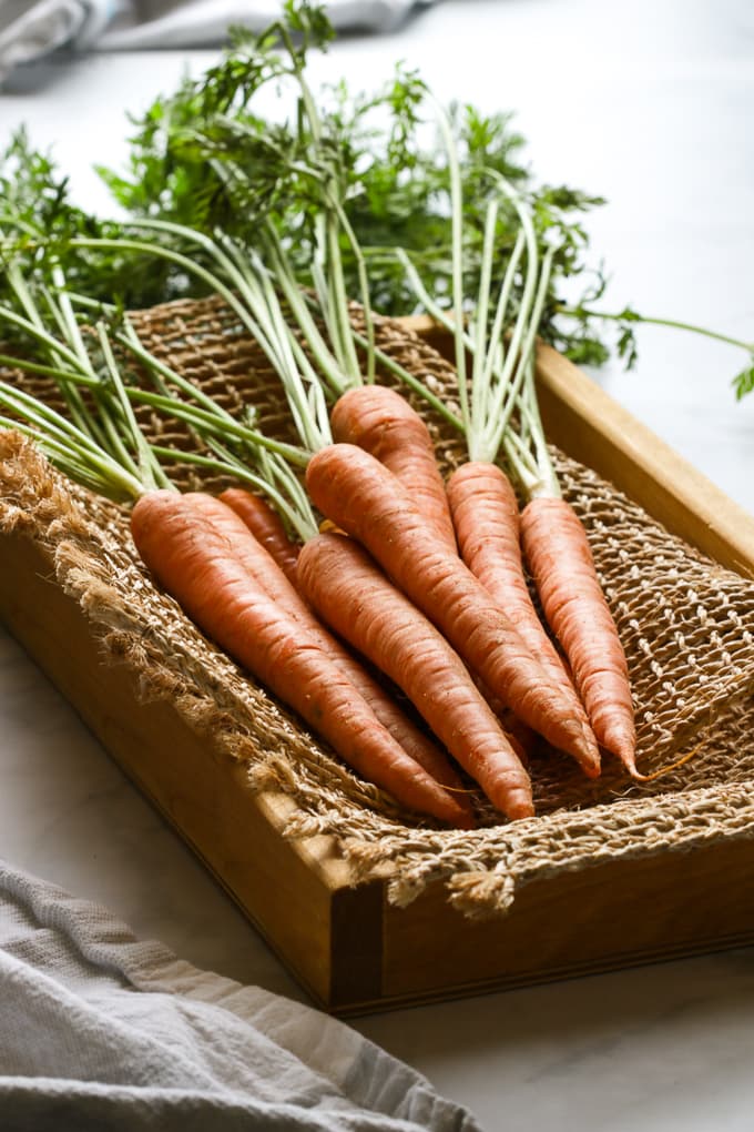 Baby carrots in a brown wooden box.