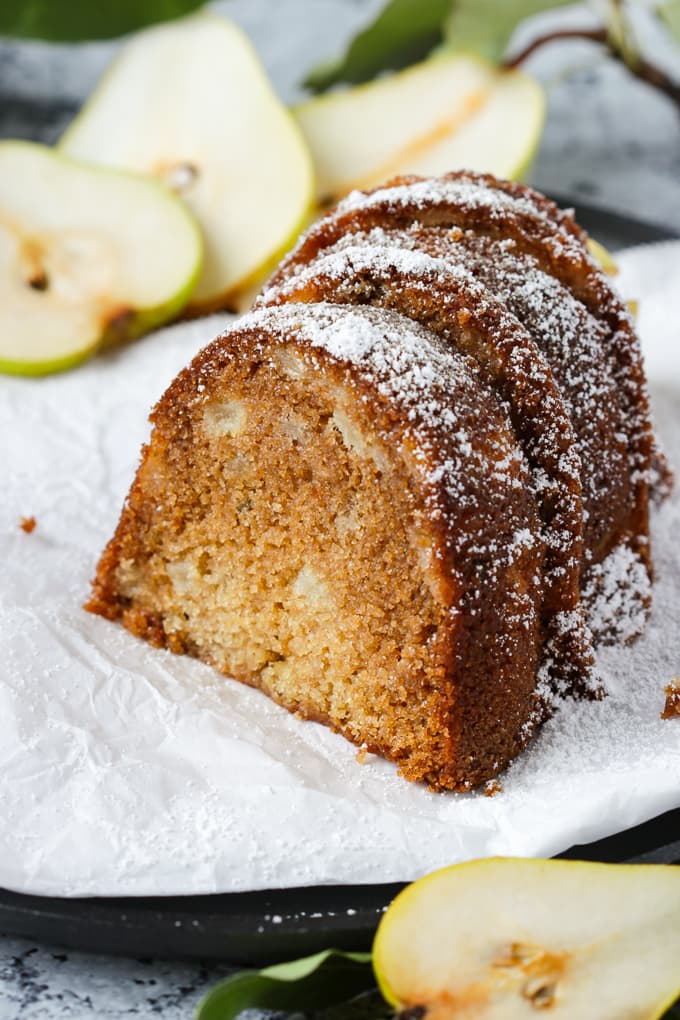 Three slices of pear and honey cake on parchment paper.