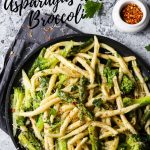 Italian fusilli pasta with broccoli and asparagus served on a black tray.