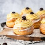 Italian Zeppole di San Giuseppe pastries on a wooden board.