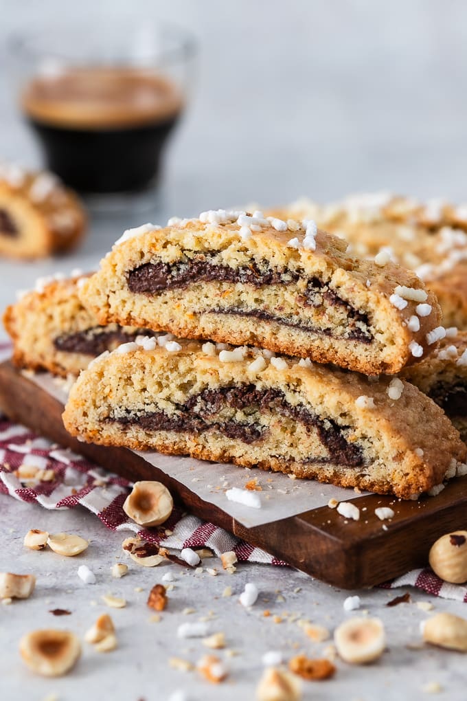 Biscotti with Nutella and hazelnuts on a wooden board.