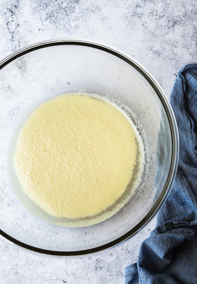 A large glass bowl with water and yeast for bread proofing.