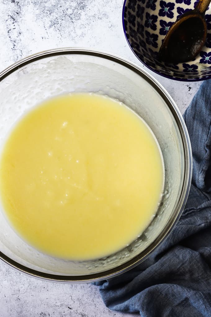 Mashed potatoes mixed with water and yeast in a large glass bowl.