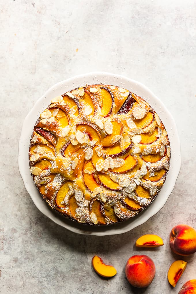 Gluten free Peach and Almond cake on a white cake stand.