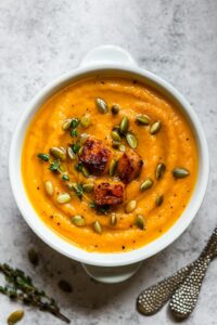 Roasted butternut squash soup garnished with pumpkin seeds.