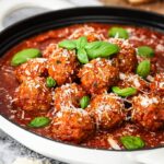 Meatballs with tomato sauce in white cooking pan.