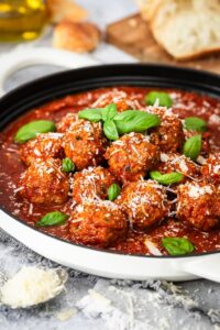 Meatballs with tomato sauce in white cooking pan.